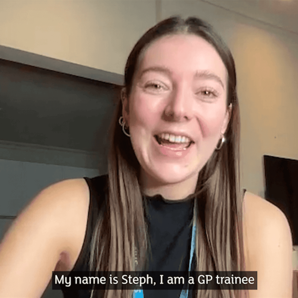 Dr Stephanie Slater is smiling at the camera. She has long brown hair and is wearing an NHS lanyard. Subtitles say ‘My name is Steph, I am a GP Trainee’.