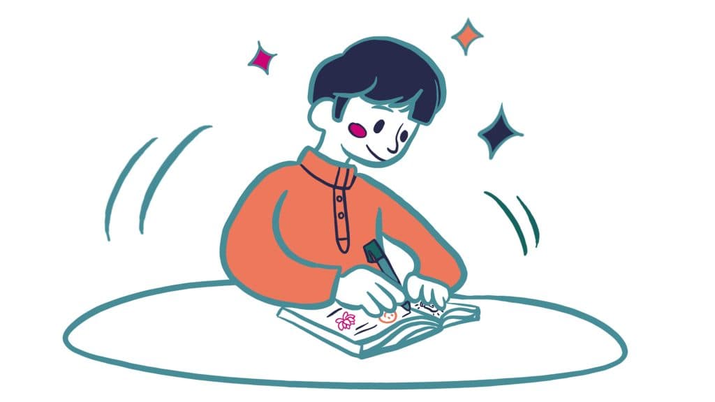 A child drawing in a notebook, sitting on the floor with a focused expression.