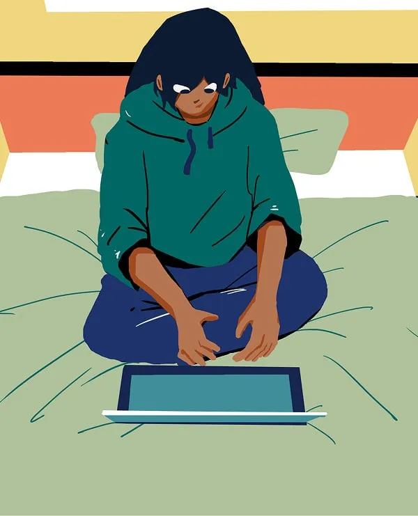 A young person sitting comfortably on bed, using a laptop.